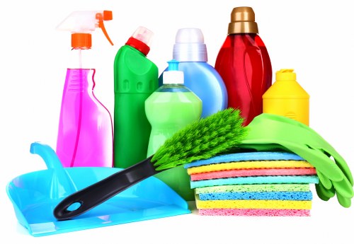 Domestic cleaner in a Camden flat preparing a living room for a regular house clean